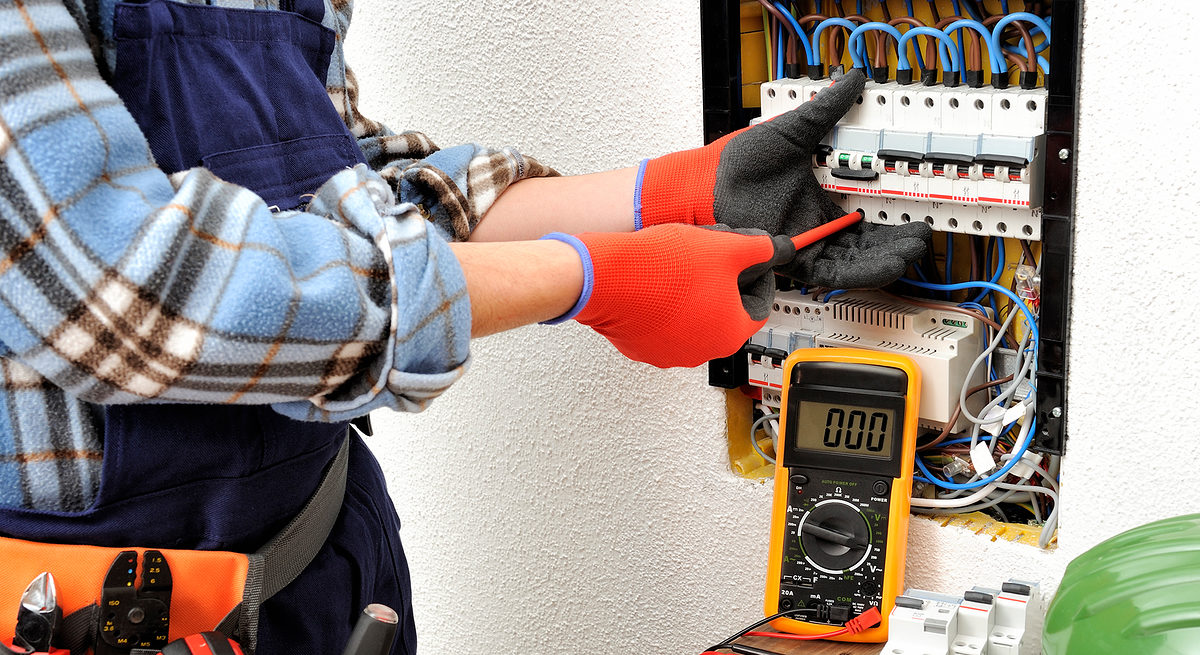 Young electrician technician fixes the electric cable to the magnetothermic switch with the screwdriver Schlagwort(e): direct current, life-saving switch, switch magnetermic, tools isolated