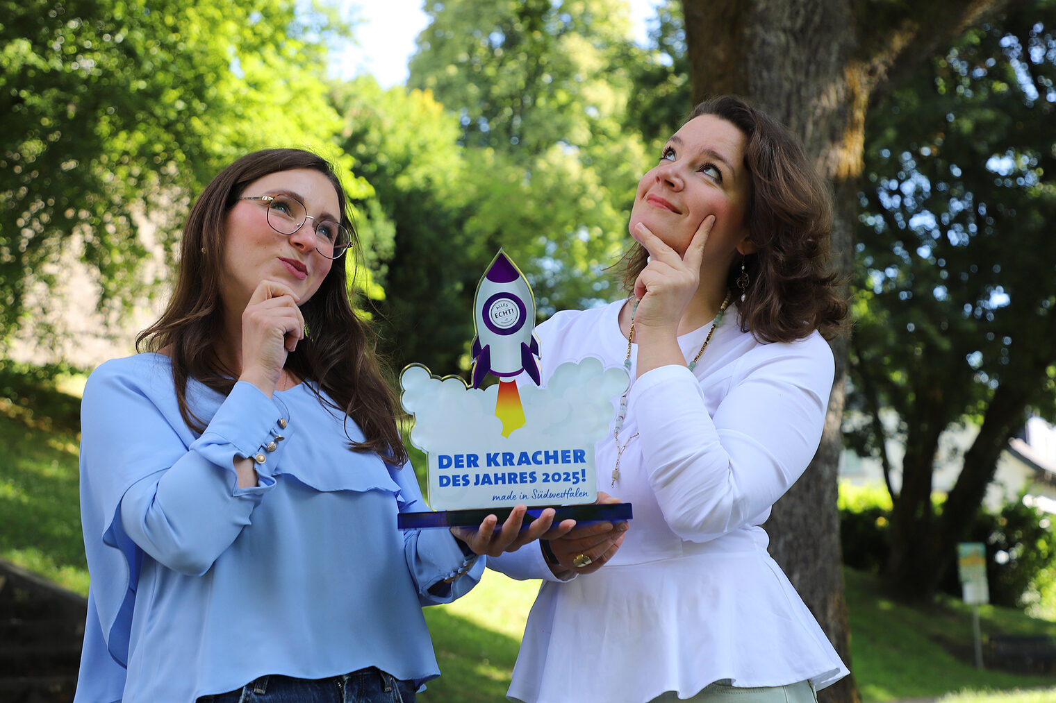 Kracher des Jahres Zwei Frauen halten die Trophäe für den Preis "Kracher des Jahres" in Südwestfalen 2025.