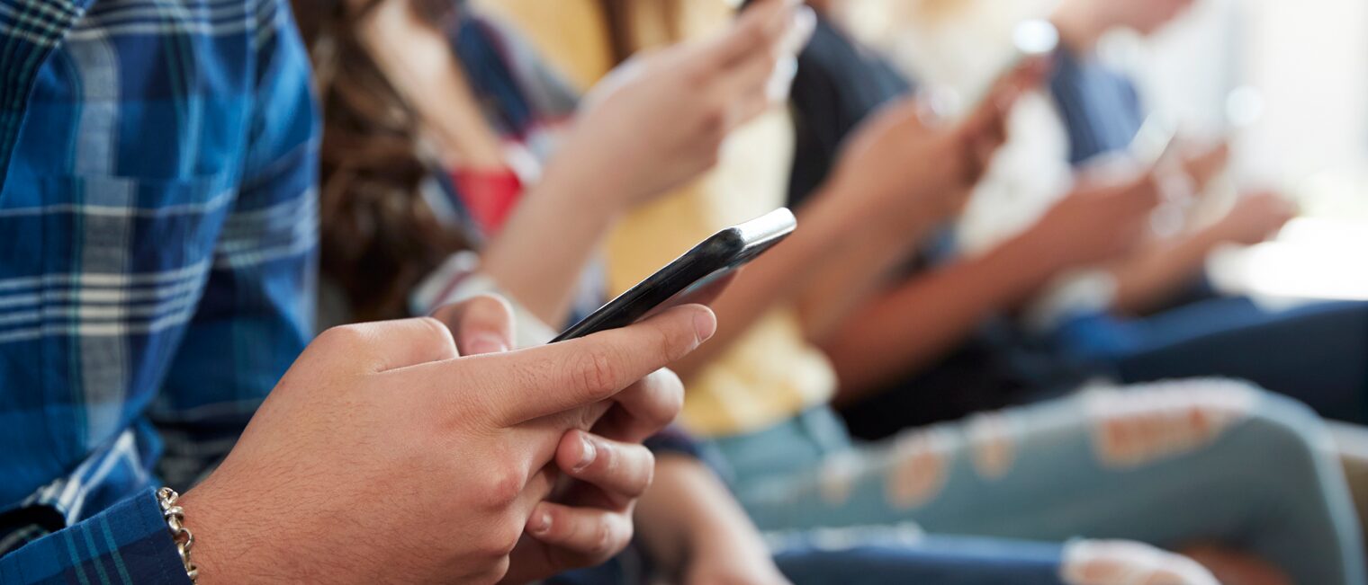 Lehrstellensuche Eine Gruppe Schüler scrollt auf ihren Smartphones.